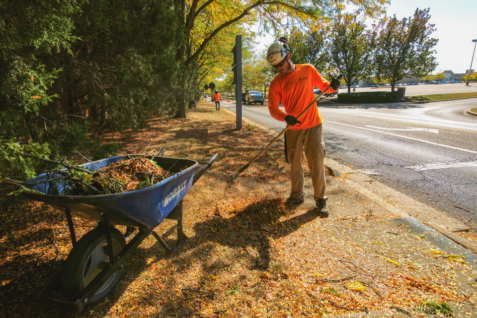 Peabody maintenance crew clearing leaves along a commercial property